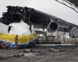 Après le retrait des troupes russes fin mars 2022, un soldat ukrainien passe devant l’épave de l’An-225 Mriya à Hostomel. L’étendue des dégâts est telle que l’appareil est irréparable.